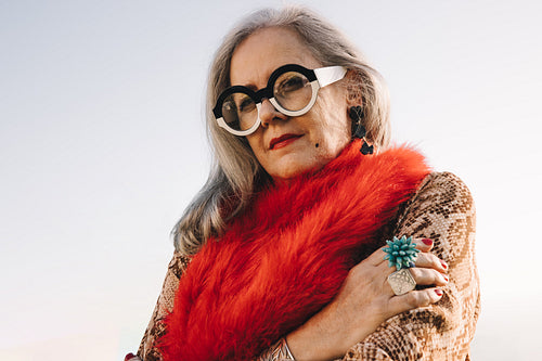 Grey-haired woman looking at the camera outdoors