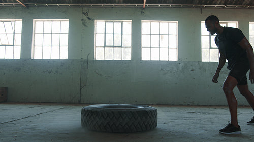 Man going tire flipping workout at gym
