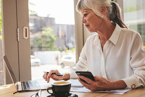 Senior businesswoman busy working at a cafe