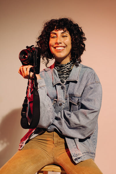 Happy young photographer holding a digital camera