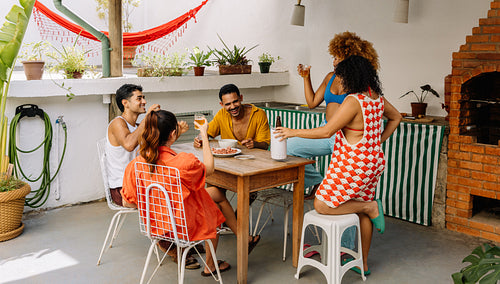 Friends enjoying a gathering outdoors in a tropical setting on a sunny day