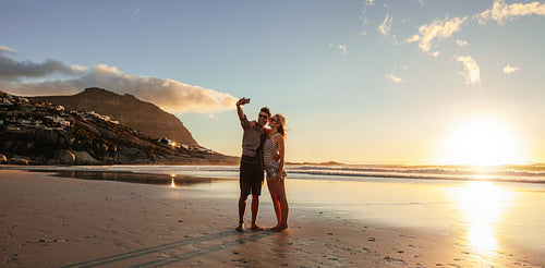 Loving young couple taking selfie at the beach