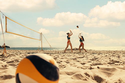 Professional beach volleyball players engaged in intense summer games on sandy shore