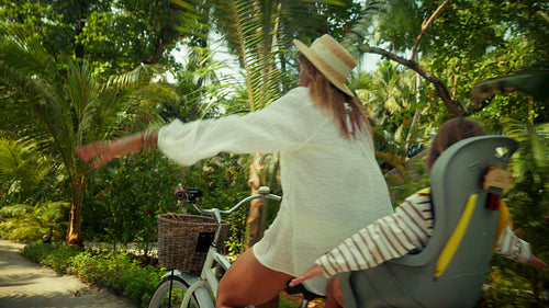 Mother and child enjoy a joyful bicycle ride at a luxury island resort