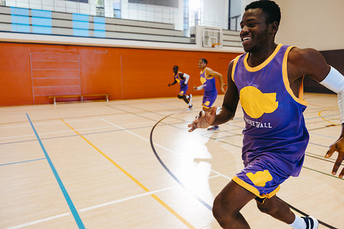 Energetic basketball players practicing on an indoor court during a game session