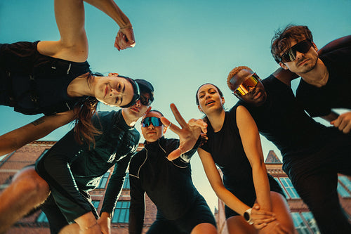 Running friends socializing outdoors in urban run club before group fitness workout