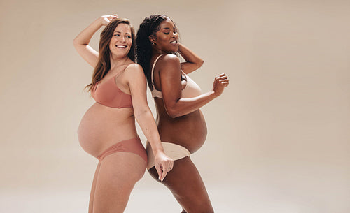 The pregnancy dance: Two young women celebrating their prenatal journey in a studio