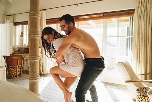 Cheerful young couple being playful in a hotel