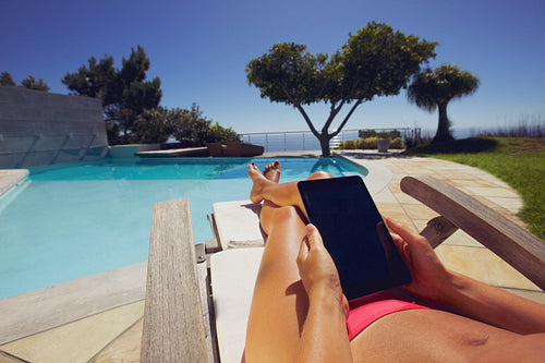 Relaxed woman using digital tablet by poolside