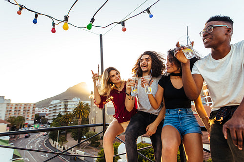 Group of friends enjoying and drinking at terrace party