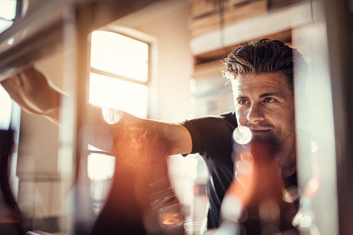 Young man working on the beer bottling machine