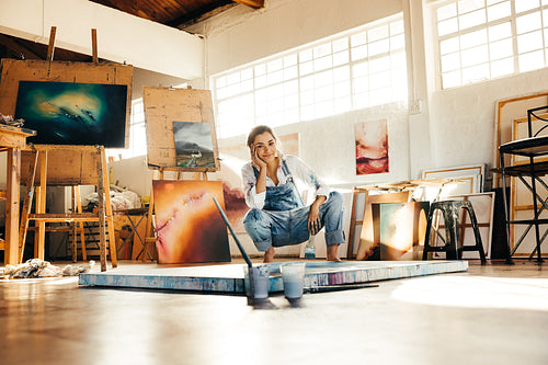 Happy young painter working in her art studio