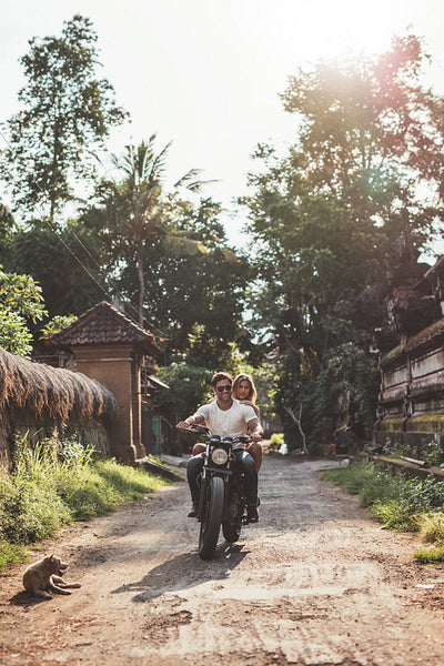 Couple enjoying motorcycle ride through a village road.