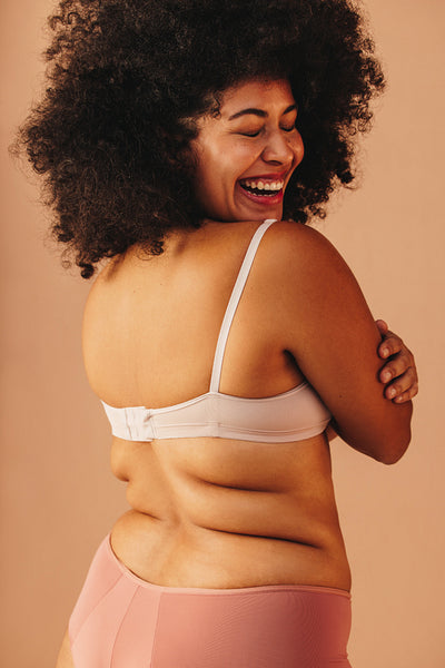 Woman with curly hair embracing her natural body in a studio