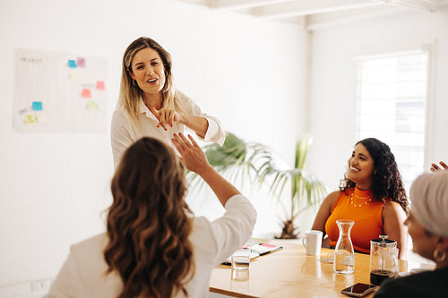 Happy businesswomen hig fiving each other in an office