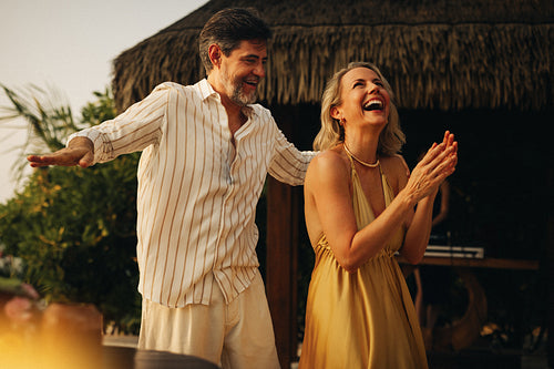 Happy couple dancing and laughing on tropical beach holiday
