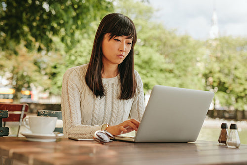 Beautiful woman using laptop at cafe