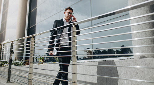 Entrepreneur walking outdoors talking on mobile phone
