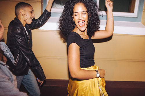 Young women dancing happily in the city at night