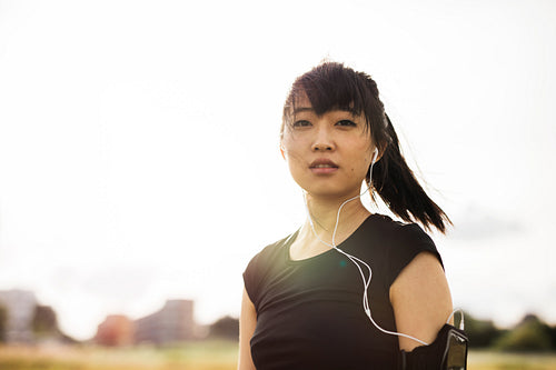 Young woman relaxing and listening music after running early morning