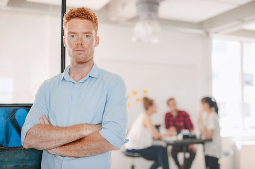 Confident young businessman standing in office