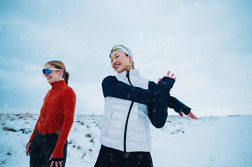Women prepare for running with stretching in the winter cold