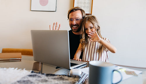 Father and daughter wave on video call