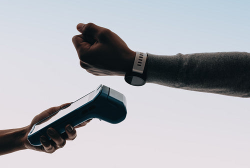 Convenient cashless checkout: Man using a smartwatch to make a payment