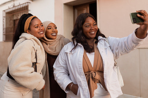 Group of diverse female friends taking a selfie together outdoor