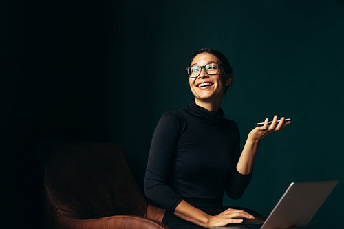 Young woman with laptop talking on phone