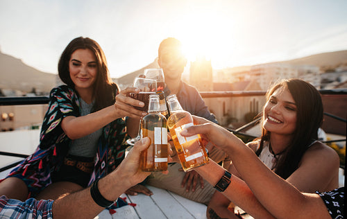 Friends toasting drinks on a rooftop party