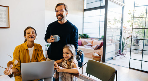 Family moment at home with laptop and coffee