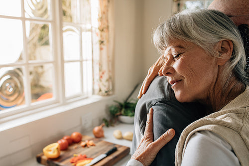 Close up of an elderly woman hugging her husband