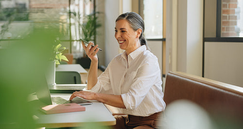 Businesswoman talking on cell phone in office