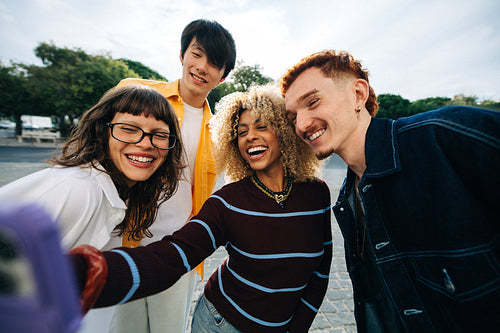 Friends taking a joyful smiling selfie outdoors together