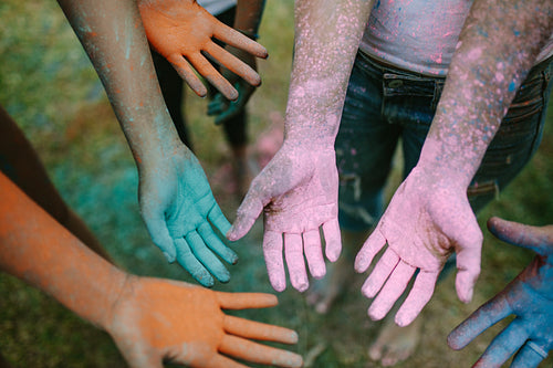 Top view of hands of people smeared with holi colours