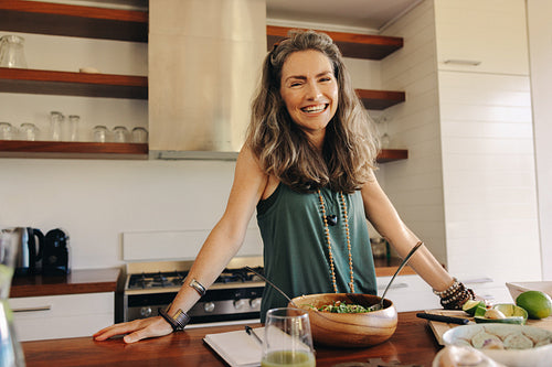 Happy vegan woman preparing a plant-based meal at home