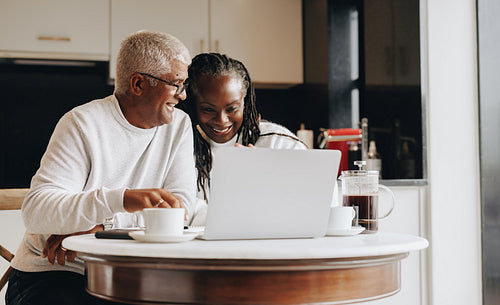 Happy senior couple having a video call at home