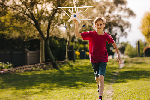 Excited boy running with a toy plane