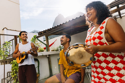 Three friends enjoying music with pandeiro and cavaquinho outdoors
