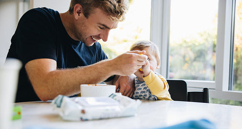 Man feeding his son with a spoon