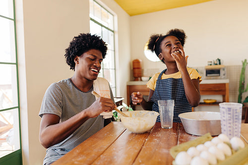 Brother and sister making traditional Brazilian bread together at home