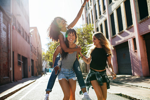 Three young woman having fun on city street