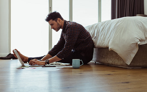 Man working on a laptop in the bedroom