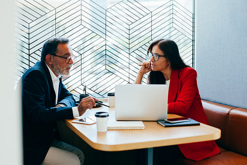 Senior business professionals discussing strategy in a modern meeting setting