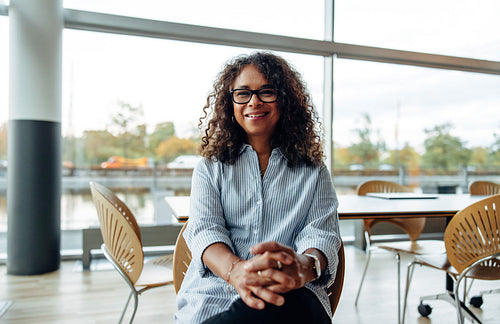 Mature businesswoman sitting relaxed in office