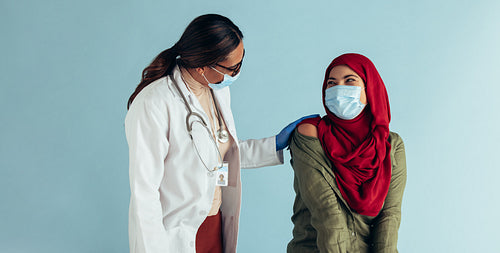 Muslim woman at doctor for vaccination