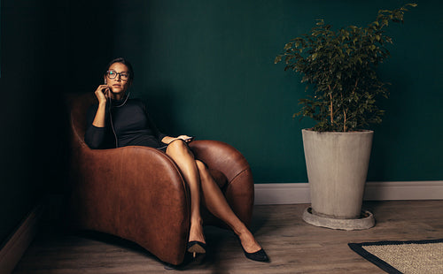 Businesswoman with earphones making a phone call