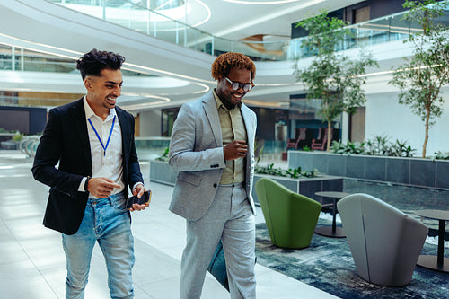 Two male accountants walking in a large office environment