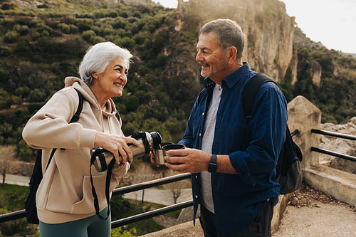 Senior couple taking a coffee break while hiking outdoors